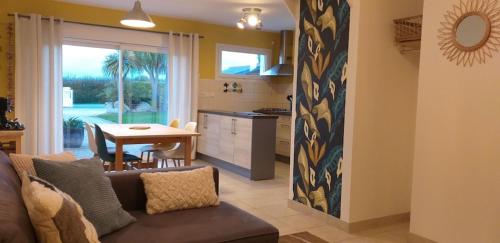 un salon avec un canapé et une cuisine avec une table dans l'établissement Le Sentier Des Dunes 