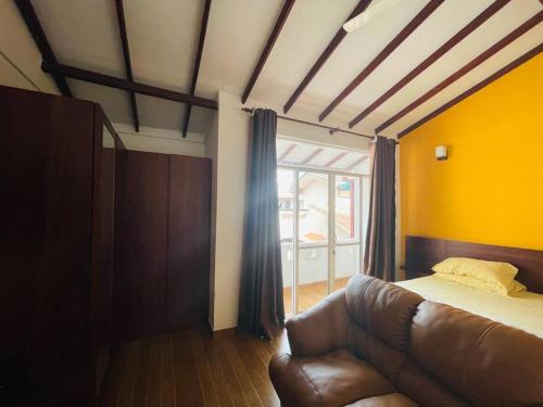 - une chambre avec un canapé et une grande fenêtre dans l'établissement 3 Bedroom House available for short/long term, à Battaramulla