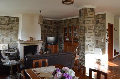 a living room with a fireplace and a table at Maria's Country House in Miranda do Douro