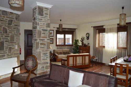 - un salon avec un canapé et un pilier en pierre dans l'établissement Maria's Country House, à Miranda do Douro