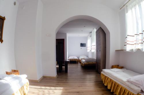 une chambre avec deux lits et un couloir avec deux lits dans l'établissement Galeria PRL, à Borne Sulinowo