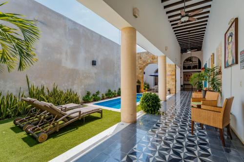 a courtyard with lounge chairs and a swimming pool at Casona Las Tres Marías - Hotel Only adults in Mérida