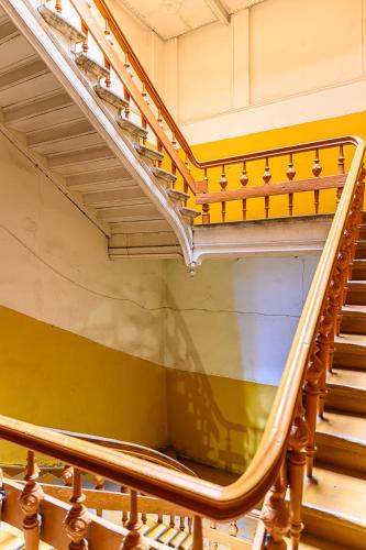 a spiral staircase in a building with yellow walls at Teatrum in Liepāja