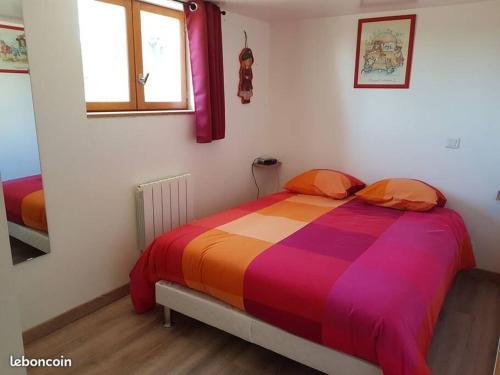 een slaapkamer met een bed met een kleurrijk dekbed bij Chalet de charme climatisé sur la route du Ventoux in Carpentras
