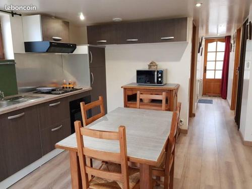 a kitchen with a table and chairs in a kitchen at Chalet de charme climatisé sur la route du Ventoux in Carpentras