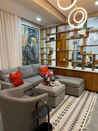 a living room with a couch and chairs and a chandelier at Lux Ph & Rooftop Terrace to Relax in Santiago de los Caballeros