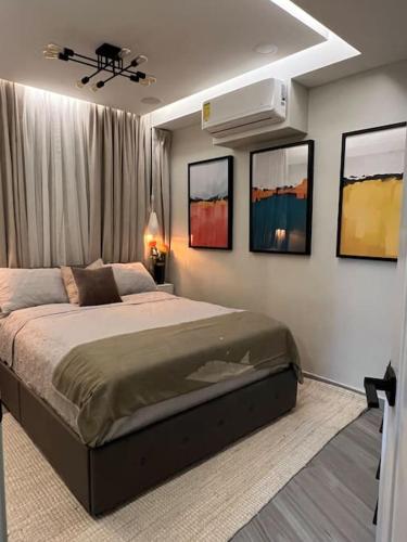 a bedroom with a bed and paintings on the wall at Lux Ph & Rooftop Terrace to Relax in Santiago de los Caballeros