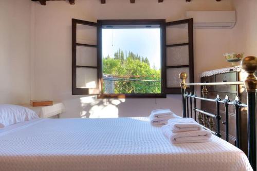 a bedroom with a bed and a window with towels at Villa Verde in Kounavádes