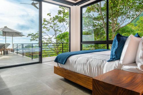 a bedroom with a bed and a view of the ocean at Amigos Por La Vida in Dominical