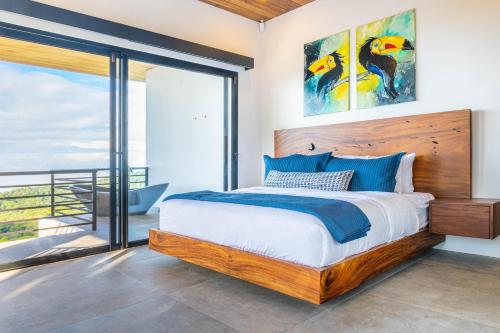 a bedroom with a king sized bed and a balcony at Casa Amigos - By Pura Villas in Dominical