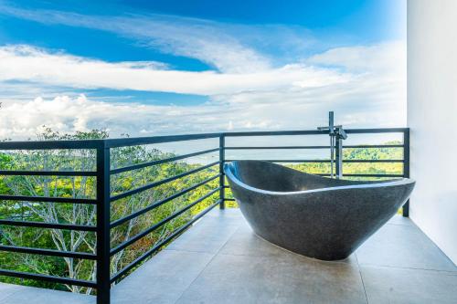 a bathroom with a bath tub on a balcony at Casa Amigos - By Pura Villas in Dominical