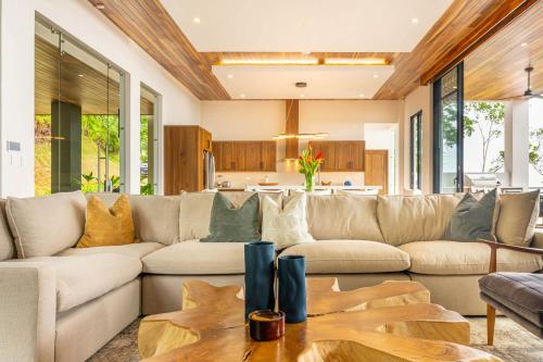 a living room with a large couch and a table at Casa Amigos - By Pura Villas in Dominical