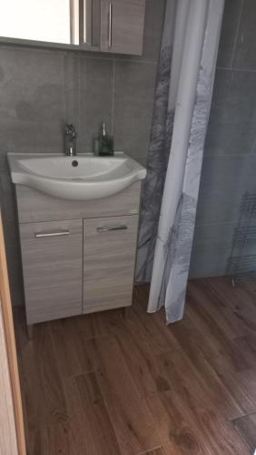 ein Badezimmer mit einem weißen Waschbecken und einer Dusche in der Unterkunft Bicik-Lak in Balatonfůzfő