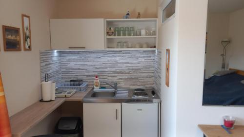 eine kleine Küche mit einer Spüle und einer Theke in der Unterkunft Bicik-Lak in Balatonfůzfő