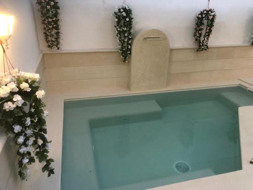 una piscina en una habitación con flores en la pared en Glem Luxury, en Copertino
