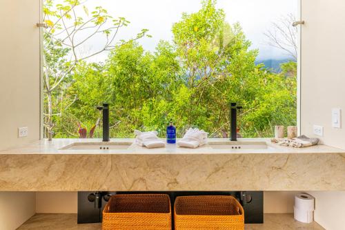 a bathroom with two sinks and a large window at Casa Grande del Mar - by Pura Villas in Punta Mala