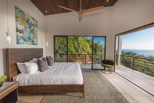 a bedroom with a bed and a large window at RESOL Secluded Ocean-view luxury in the Jungle in Uvita