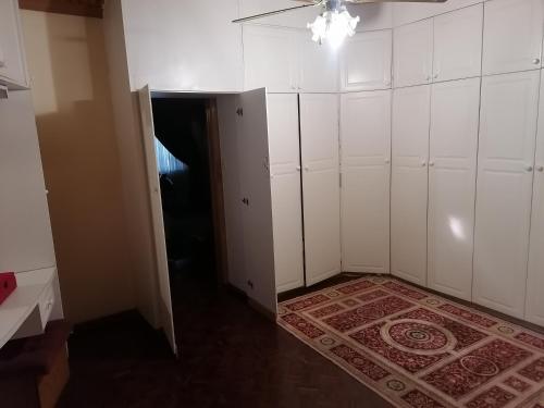 an empty room with white cabinets and a rug at Tjibelu's Nest Guest Home in Lobatse