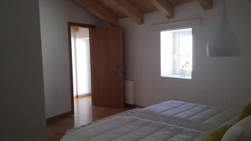 a white room with a bed and a window at Casas de Campo da Barroca in Tabosa