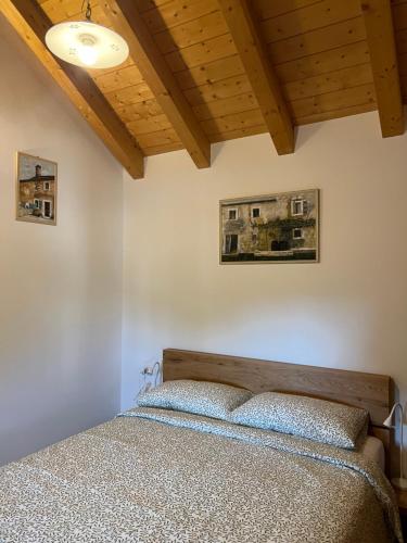 a bedroom with a bed and a wooden ceiling at Appartamenti Minerva in San Pelagio