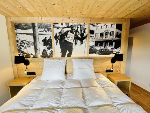 a bed in a bedroom with pictures on the wall at Le Refuge Cal Chalon , chalet de luxe au cœur du village in Les Angles