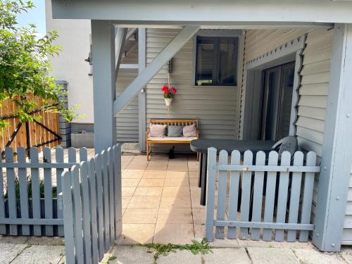 un porche con una mesa y una valla en Maison chaleureuse - Gérardmer, en Gérardmer