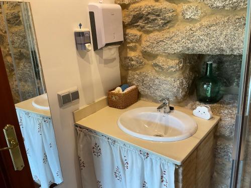 a bathroom with a sink and a counter with a mirror at Da man da Moura in Ourense