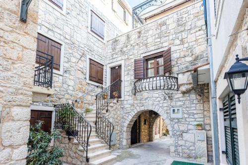 an alleyway in an old stone building with stairs at Stone House Srida in Baška Voda