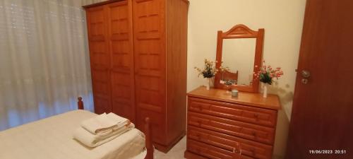 a bedroom with a bed and a dresser with a mirror at Apartamento Varanda do Sol in Amora