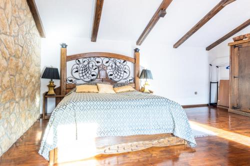 a bedroom with a large bed with a wooden headboard at Stone House Srida in Baška Voda