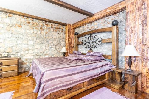 a bedroom with a bed and a stone wall at Stone House Srida in Baška Voda