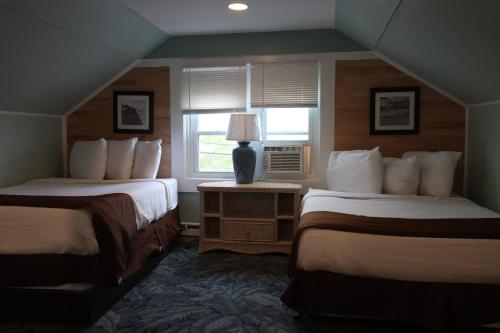 ein Hotelzimmer mit 2 Betten und einem Fenster in der Unterkunft The Burgundy Inn Hotel and Apartments in Ocean City