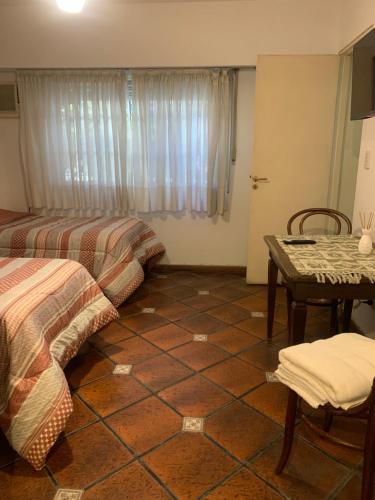 a room with two beds and a table and a window at Comfort Suite in Vicente López