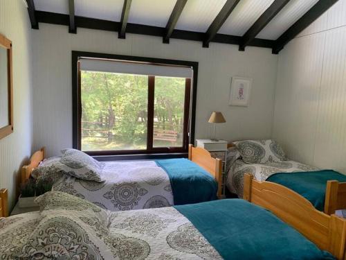 um quarto com 2 camas e uma grande janela em La casita de Las Trancas em Pinto