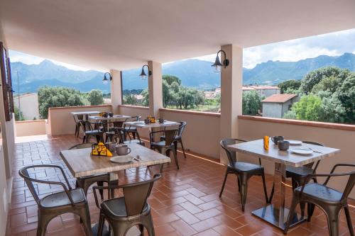 a restaurant with tables and chairs and large windows at NONNU NONNA in Padru