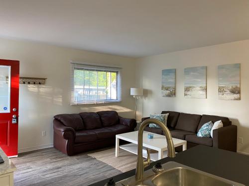 Il dispose d'une cuisine et d'un salon avec un canapé et une table. dans l'établissement 2 bedroom, sleeps 7 in Wasaga Beach, à Wasaga Beach