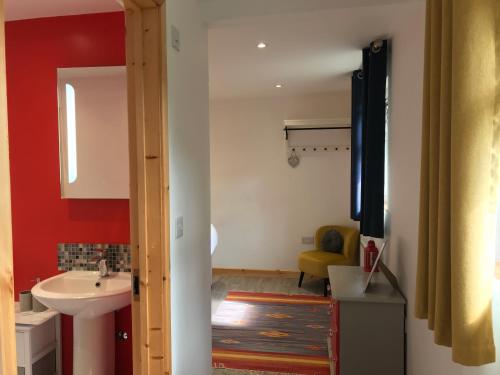 a bathroom with a sink and a toilet and a mirror at Woodpecker Glamping Cabin in Bodmin