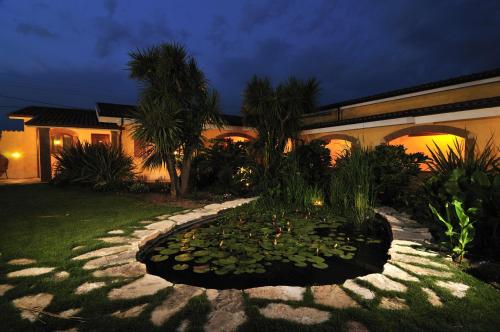 a house with a pond in front of a yard at La Locanda del Cavaliere in Borgo Montello