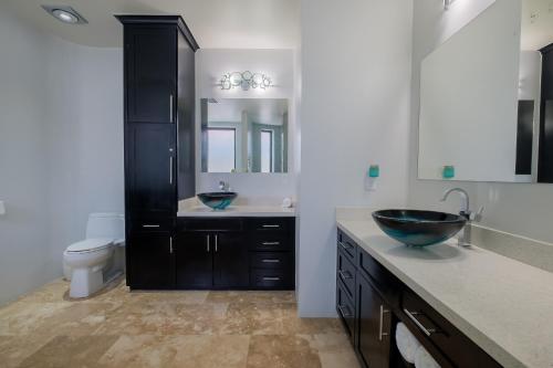 a bathroom with two sinks and a toilet at Diamante Beachfront Suites in San Pedro