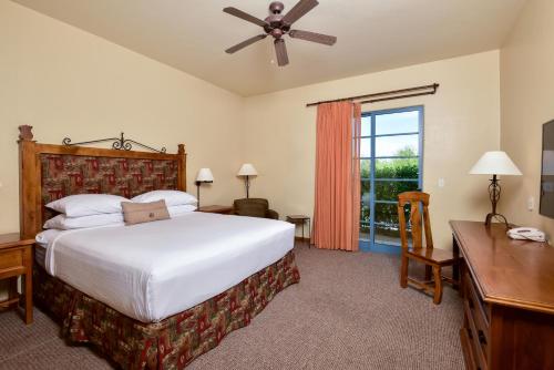 a bedroom with a bed and a desk and a window at Lodge On The Desert in Tucson