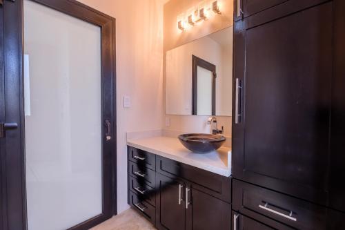 a bathroom with a sink and a black cabinet at Diamante Beachfront Suites in San Pedro