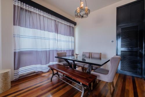 a dining room with a wooden table and chairs at Diamante Beachfront Suites in San Pedro
