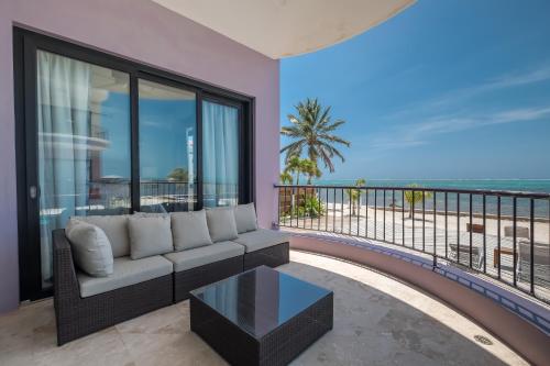 a living room with a couch and a view of the ocean at Diamante Beachfront Suites in San Pedro