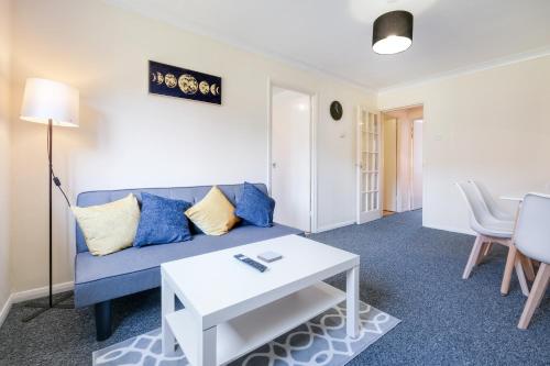 a living room with a blue couch and a table at Harry Potter, Warner Brothers Apartment - Watford Junction - Watford FC - Free Parking in Watford