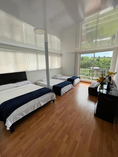 a bedroom with two beds and a large window at La Martina Palestina in Palestina