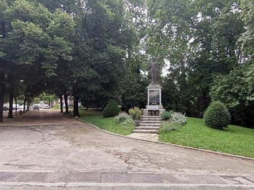 a statue sitting in the middle of a park at Love Room avec spa in Nérac
