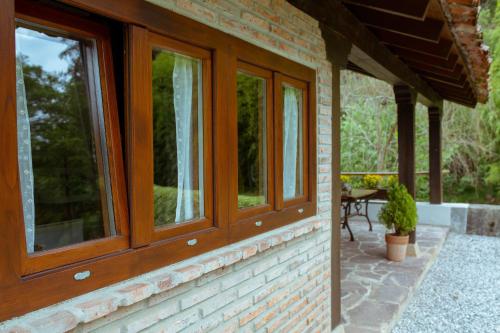 a brick house with windows and a patio at El Molino de Bonaco in San Vicente de la Barquera