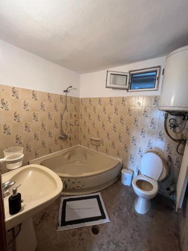 y baño con bañera, aseo y lavamanos. en Kerdilia apartments #1 en Néa Kerdhília