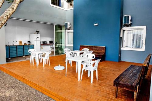 a dining room with white tables and white chairs at Pousada Silvestre in Tramandaí