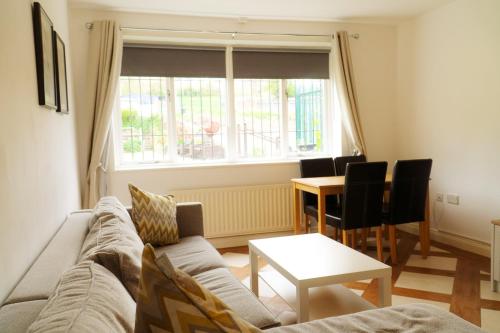 a living room with a couch and a table and a window at Great offers on Long Stays!! LaLuNa Apartments in Gateshead